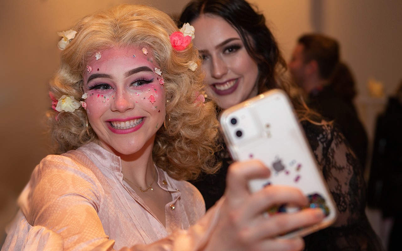 Two students in stage make-up pose for a selfie at the Moveable Feast benefit