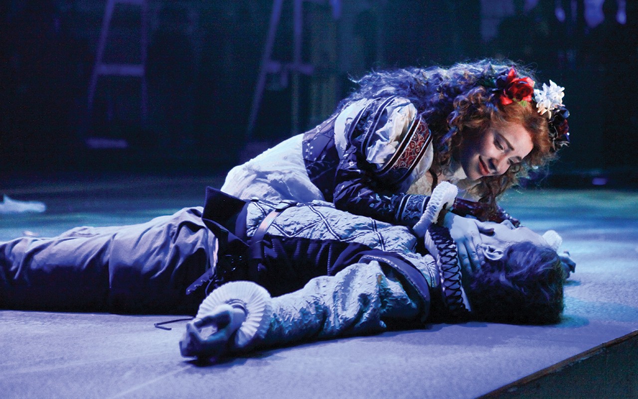 A male and female actor embrace on stage during a performnce of Romeo and Juliet