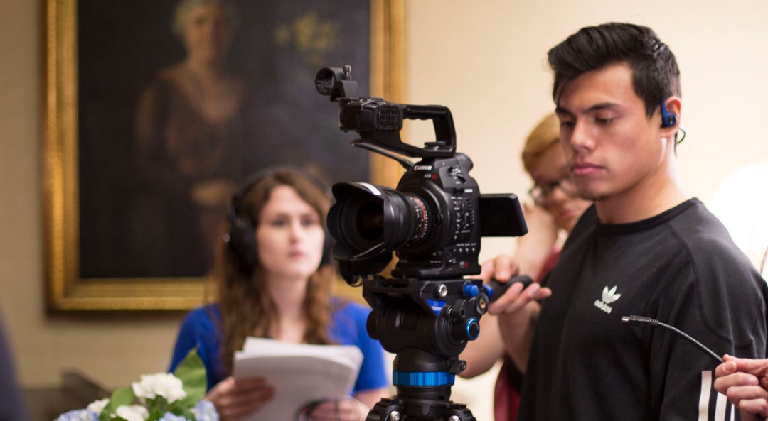 A student operates a camera during a video shoot.