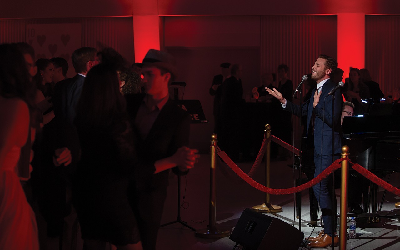 Vocalist performs near the dance floor at the Saints & Sinners Bash