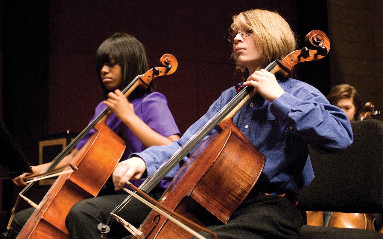 Two high school aged cello students perform on the Corbett Auditorium stage